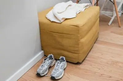 two pairs of shoes sitting next to a yellow ottoman at Trevi Fountain Apartment - ZENO 03 in Rome
