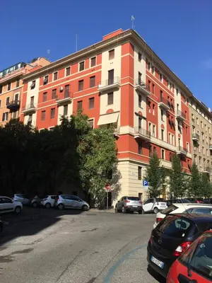 a large building with cars parked in a parking lot at Almachiara in Rome
