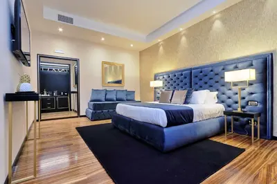 a large bedroom with a large bed and a couch at Spanish Diamond Luxury Suites & Jacuzzi in Rome