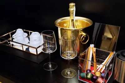 a bottle of wine is being poured into two wine glasses at Spanish Diamond Luxury Suites & Jacuzzi in Rome