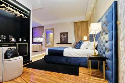 a bedroom with a large bed with a blue headboard at Spanish Diamond Luxury Suites & Jacuzzi in Rome