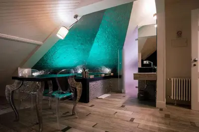 a dining room with a table and a blue wall at SuiteFrattini Private Spa in Rome