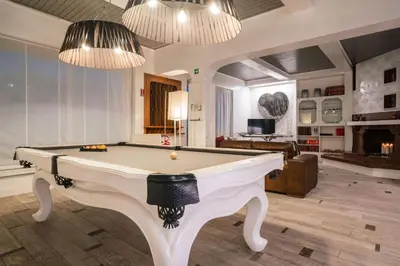 a living room with a pool table and two chandeliers at SuiteFrattini Private Spa in Rome