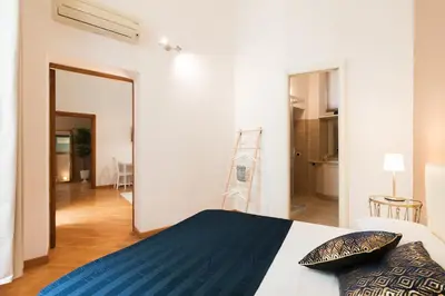 a bedroom with a bed with blue sheets and a mirror at VENETO AVENUE in Rome