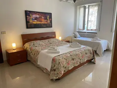 a hotel room with two beds and a window at Roma Apartment in Rome