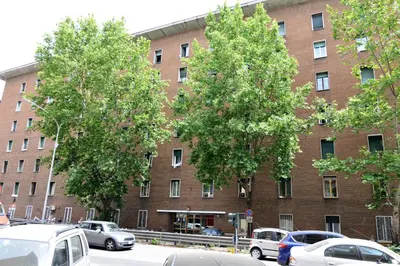 a large brick building with cars parked in front of it at AFFITTACAMERE A CASA MIA in Rome