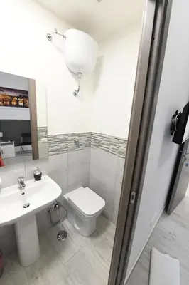 a white bathroom with a toilet and a sink at AFFITTACAMERE A CASA MIA in Rome