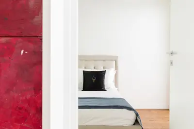 a bedroom with a bed with a red wall at A World Aparts - 104 Frattina in Rome
