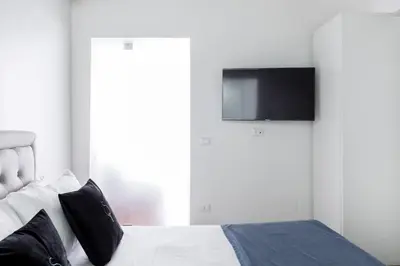 a bedroom with a bed with a tv on the wall at A World Aparts - 104 Frattina in Rome