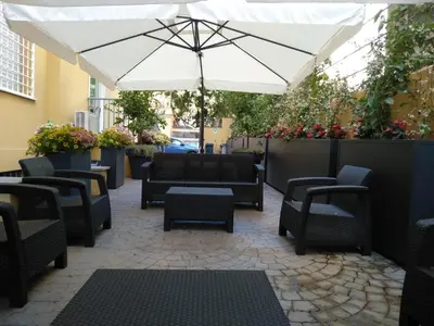 an outdoor patio with chairs and an umbrella at ASTORIA GOLDEN GATE in Rome
