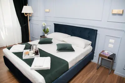 a large bed in a room with a green and white bedvisor at Unicum Roma Suites in Rome