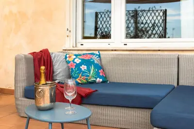 a couch with a bottle of wine and a glass on a table at Penthouse Rome Capitol in Rome