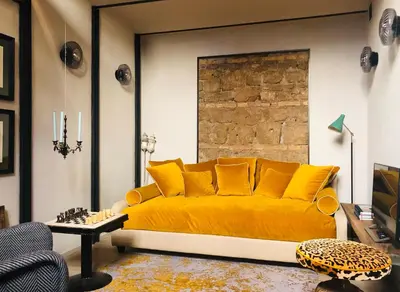 a couch with yellow pillows in a living room at Boutique Loft steps from the Colosseum - Gio Roma in Rome