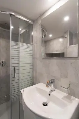 a white bathroom with a sink and a shower at POPOLO PEN 56 Apartament in Rome