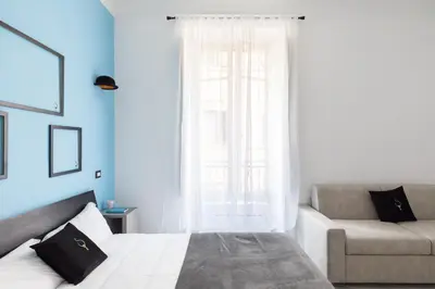 a bedroom with a bed and a couch and a window at A World Aparts - 23 Artisti in Rome