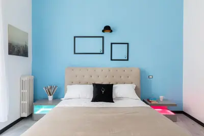 a bedroom with blue walls and a large bed at A World Aparts - 23 Artisti in Rome