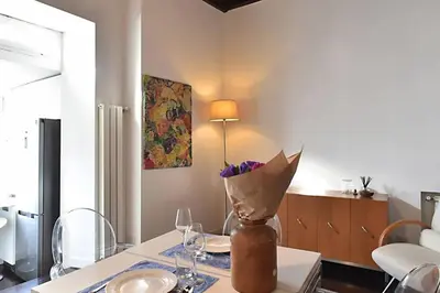 a dining room table with a vase of flowers on it at Delizioso appartamento a Campo de' Fiori in Rome