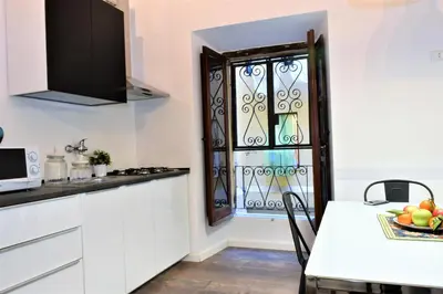 a kitchen with white cabinets and a window at Miriam Apartment in Rome