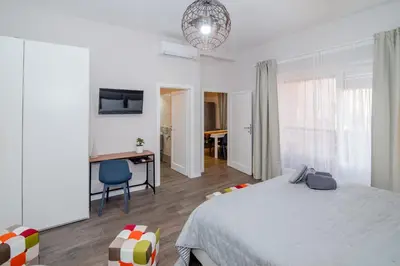 a bedroom with a bed and a desk and a chair at La RomAntica Roma in Rome