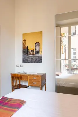 a bedroom with a desk and a bed and a mirror at HospitalityRome Domus Aureliana in Rome
