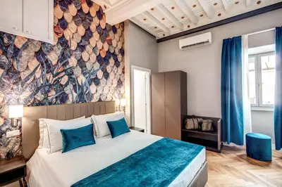 a bedroom with a large bed with blue pillows at Maison d'Art Apartments - Maison d'Art Collection in Rome