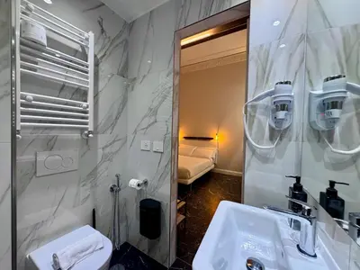 a bathroom with a sink and a toilet and a mirror at Room Roma Nazionale in Rome