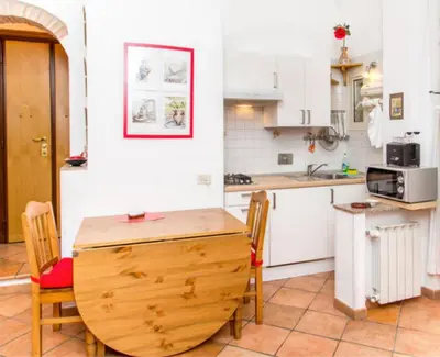 a kitchen with a wooden table and chairs in a room at Charming Studio near the Colosseum in Rome, 45 m² with Balcony in Rome