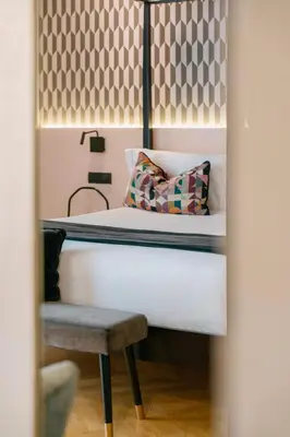 a bed in a room with a chair and a pillow at NAMAN HOTELLERIE - Margutta in Rome