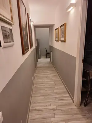 a hallway with a tile floor and paintings on the walls at Vatican Tolemaide 2 in Rome