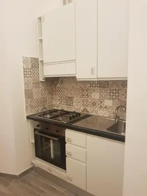 a kitchen with white cabinets and a stove and a sink at Vatican Tolemaide 2 in Rome
