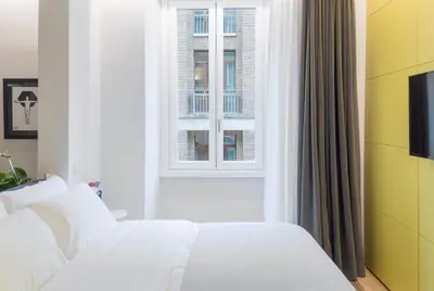 a bedroom with a white bed and a window at The Radical Hotel Roma in Rome