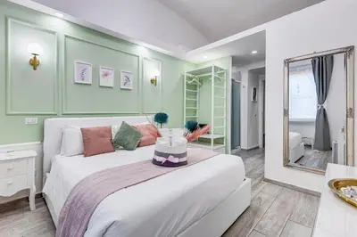 a bedroom with a large white bed with a mirror at Maison Risorgimento in Rome