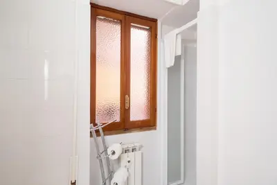a bathroom with a window and a toilet paper dispenser at Magenta Collection Terrione 17 in Rome