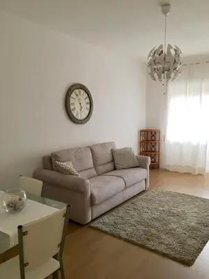 a living room with a couch and a clock on the wall at Casa Milù in Rome
