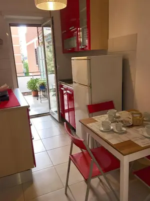 a kitchen with a table with chairs and a refrigerator at Casa Milù in Rome