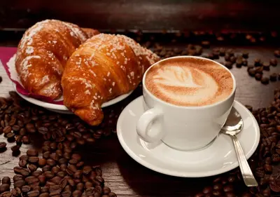 a cup of coffee and croissants and coffee beans at Dulcis In Vatican b&b in Rome
