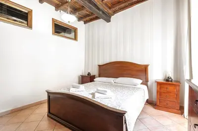 a bedroom with a large bed with a wooden frame at Confortevole Appartamento nel Centro Storico con 2 camere AC WiFi in Rome