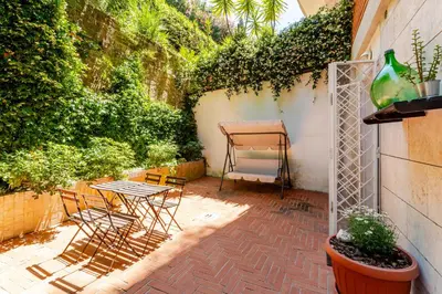 a patio with chairs and a table and plants at St. Peter Garden House in Rome
