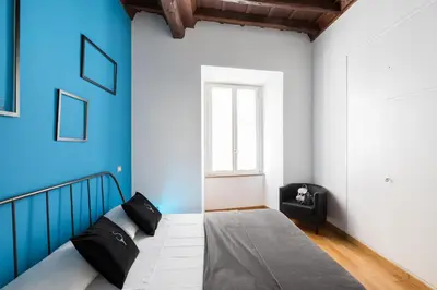 a bedroom with a bed and a blue wall at A World Aparts - 87 Boschetto in Rome