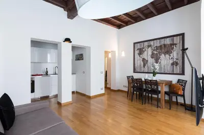 a living room with a table and chairs and a kitchen at A World Aparts - 87 Boschetto in Rome