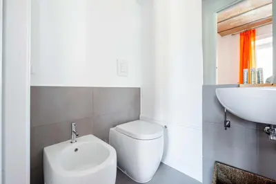 a bathroom with a white toilet and a sink at Saint Peters Luxury 3 Bedrooms Apartment in Rome