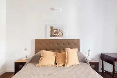 a bedroom with a bed with two pillows and a piano at Saint Peters Luxury 3 Bedrooms Apartment in Rome