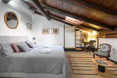 a bedroom with a bed and a chair and a table at Casa Nora in Rome