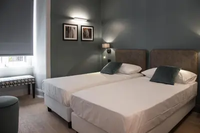 two beds in a small room with twoermottermott at Domus Alberico in Rome
