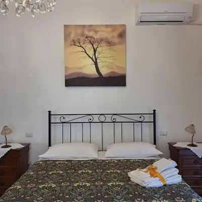 a bedroom with a bed with a painting on the wall at ART APARTMENT VILLA FIORELLI in Rome