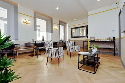 a living room with chairs and a table at Roma Five Suites in Rome