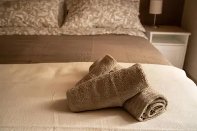 a folded towel sitting on a bed at Sogno di un'epoca in Rome