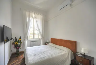 a white bedroom with a bed and a window at Rome Luxury House - The House in Rome