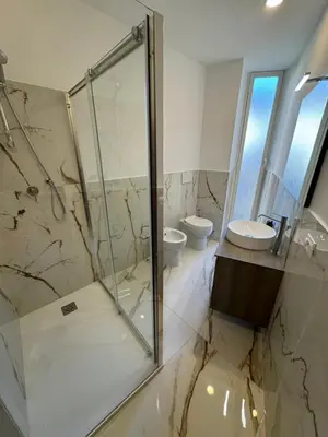 a bathroom with a glass shower and a sink at Rome Luxury House - The House in Rome