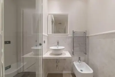 a white bathroom with a sink and a mirror at Loft Farnese luxury 3 stanze 3 bagni salotti cucina in Rome